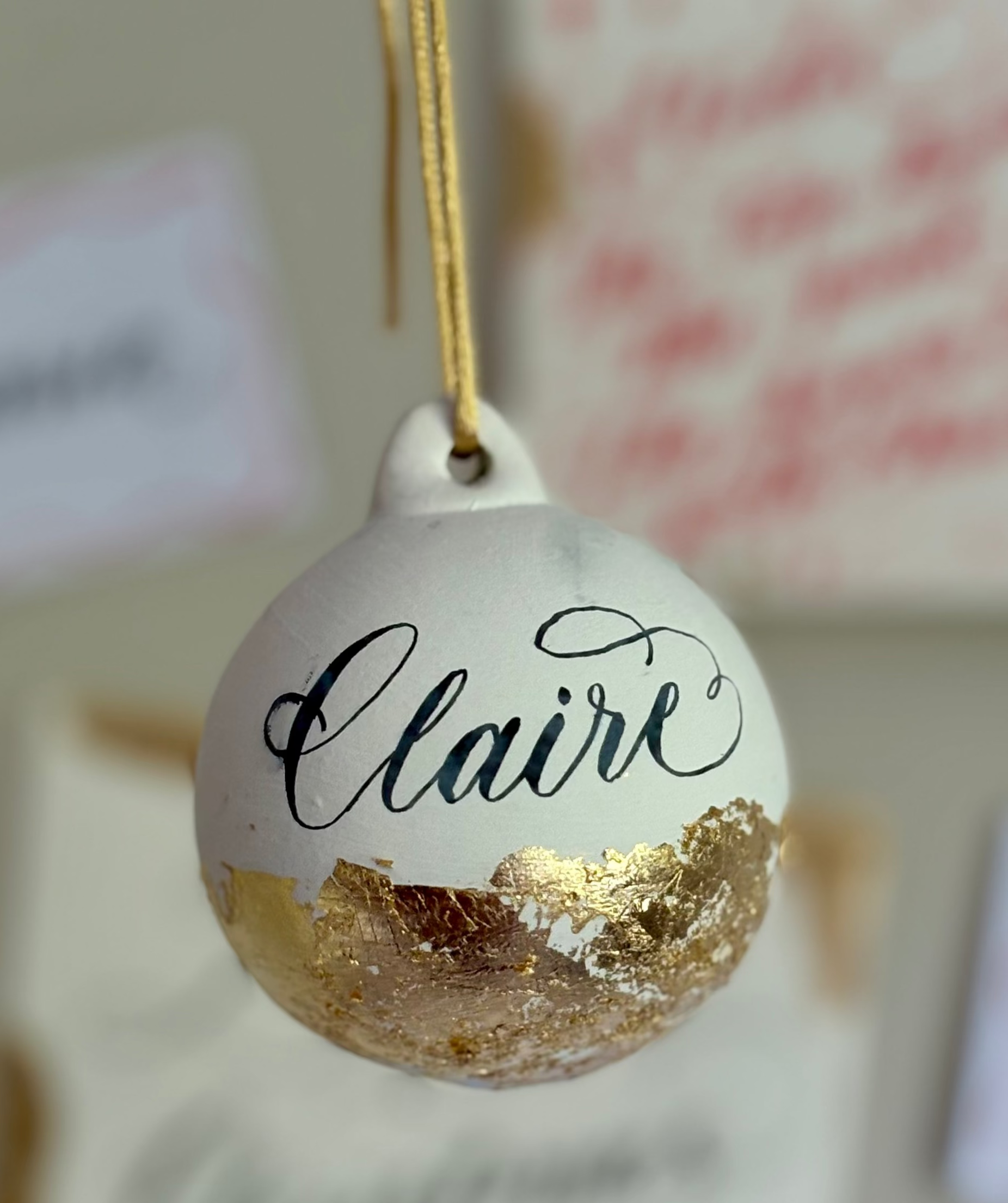 Decorative bauble ornament with Claire written on it with calligraphy lettering style